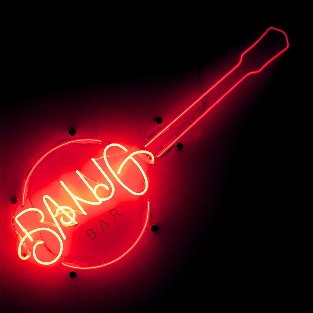 An illuminated Banjo-shaped neon sign