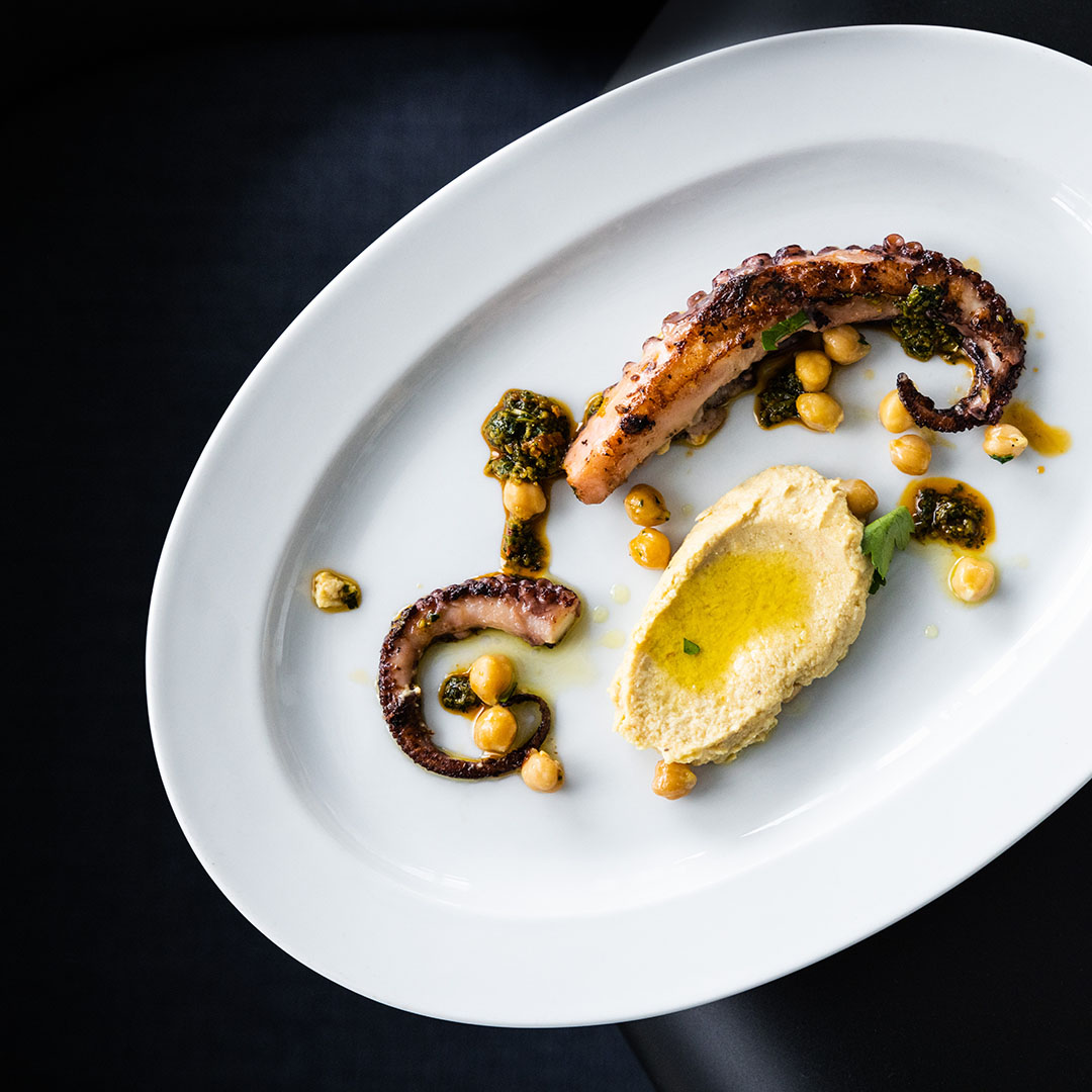 An elegant dish with octopus and hummus